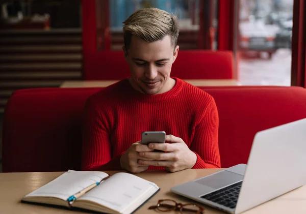 Retrato Homem Bonito Camisola Vermelha Usando Telefone Celular Procurando Informações — Fotografia de Stock