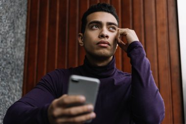 Başarılı kariyer hakkında hayal Afrikalı-Amerikalı adam cep telefonu tutarak ve mobil uygulamalar için iş arama online, kullanarak ciddi duygusal yüz. Bir iş ve işsizlik stres kavramı kaybetmek.  
