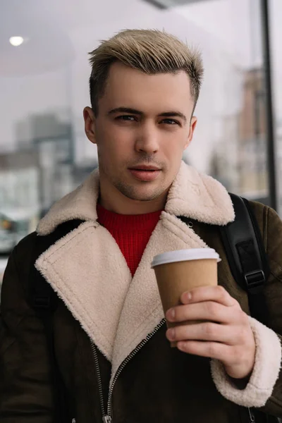 Stylish man drinks coffee outdoors