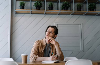 Ciddi adam çalışma serbest proje, düşünme, işyerinde beyin fırtınası not yazmak. Eğitim, dil, sınava hazırlık öğrenme, çözüm arıyor dalgın Üniversitesi Öğrenci portresi