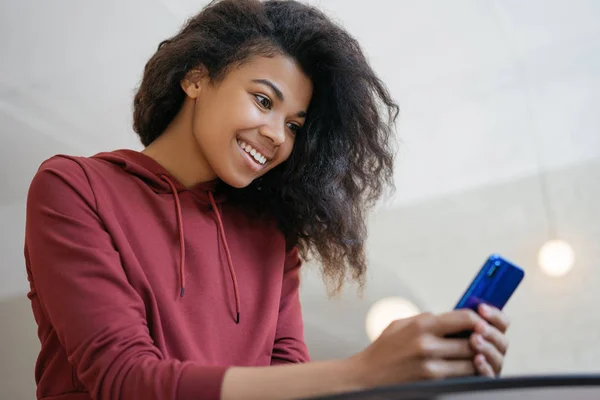 Güzel Afro-Amerikan kadın gıda online sipariş için mobil uygulama ile akıllı telefon kullanarak. Heyecanlı hipster kız cep telefonu tutan, sohbet, iletişim, bilgi arama, bilet rezervasyon. Online alışveriş. Mobil bankacılık konsepti