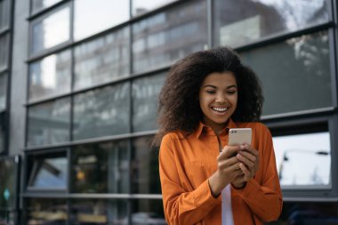 Mutlu heyecanlı kadın cep telefonu kullanıyor, Kara Cuma 'da internetten alışveriş yapıyor. Çekici duygusal hippi kız elinde cep telefonu, iletişim, internetten yemek siparişi, açık hava biletleri. 