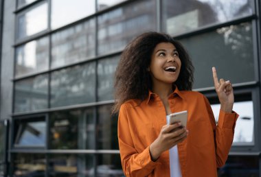 Mutlu Afrikalı Amerikalı kadın cep telefonu ve uygulama kullanarak online alışveriş yapıyor. Kara Cuma 'da indirimli fiyatlar. Duygusal hippi kız elinde akıllı telefon, web sitesinden yemek sipariş ediyor. 