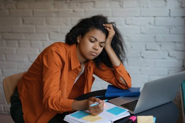 Üzgün üniversite öğrencisi, dil öğreniyor, beyin fırtınası yapıyor, notlar alıyor. Laptop, itiş kakış ve yapışkan notlar kullanarak çalışan meşgul Afrikalı Amerikalı kadın portresi. Çoklu görev, aşırı çalışma, son teslim tarihi