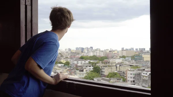 Kaukasischer Mann Schaut Aus Fenster Mit Stadt Hintergrund — Stockfoto