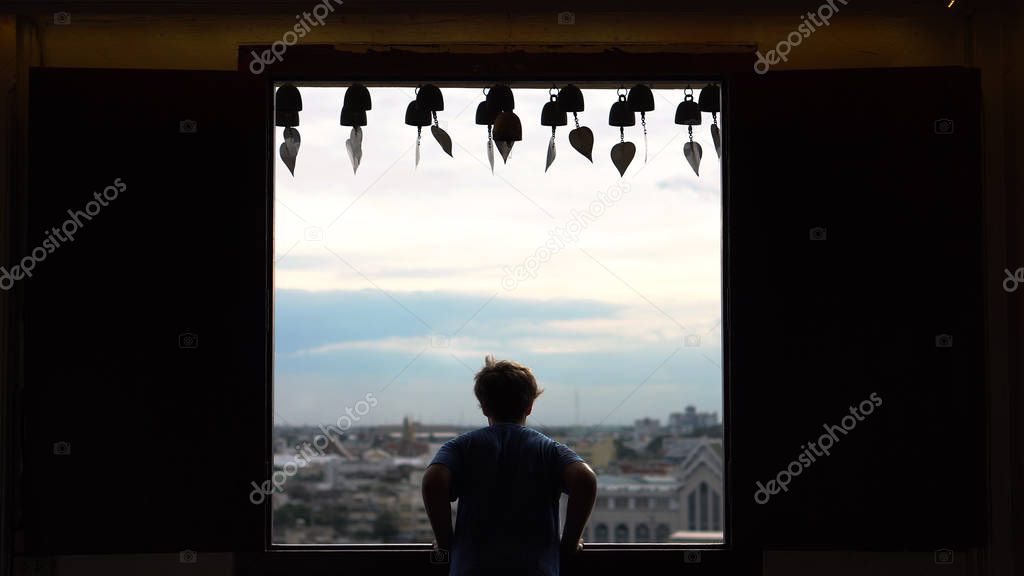 Silhouette of Young Man Looking Outside Window of Temple