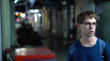 Raslantı giyimli Genç beyaz adam tehlikeli, karanlık sokakta bir şekilde - yayımlanan modeli yürüyüş