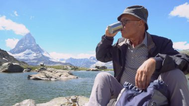 Yemek ve çay veya kahve gaza içme adam dağlarda soba