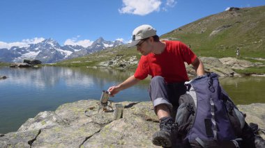 Mutlu genç Hiker kamp ocakta çay pişirme