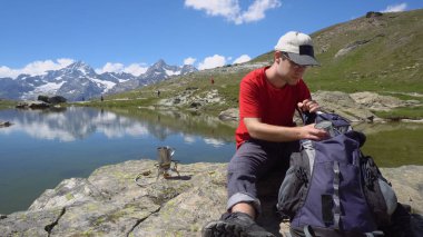 Taze içme iken doğanın keyfini gülümseyen genç adam çay veya kahve dağlarında yapılan