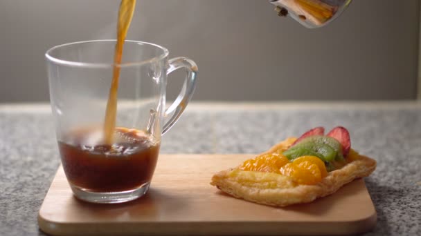 Налить свежевареный черный кофе в стеклянную чашку на кухне — стоковое видео