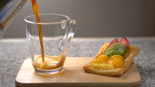 Pouring Black Coffee into Glass Cup With Pastry on Side — Stock Video