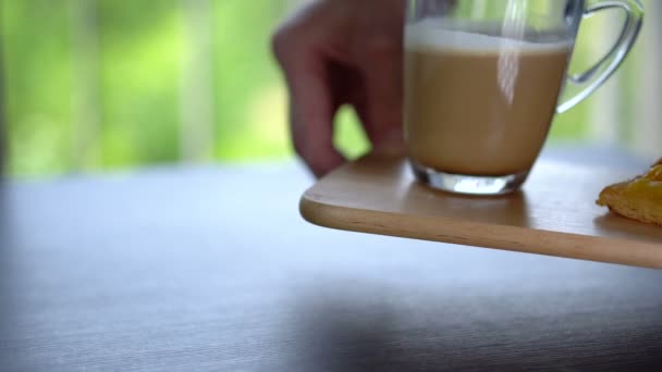 Servering av kaffe med mjölk och fruktbakelse på träbricka i restaurang — Stockvideo