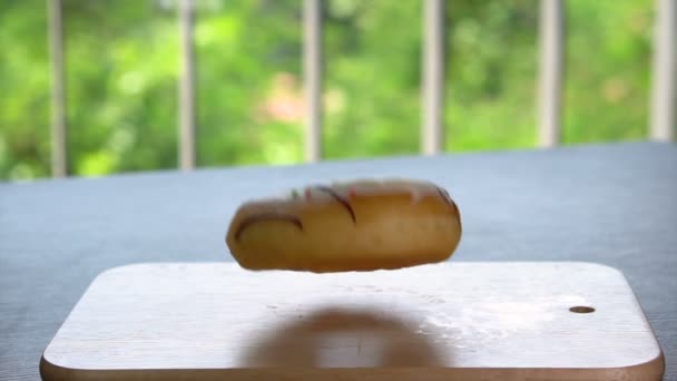 Signle Donut acristalada cayendo en la mesa de cámara lenta — Vídeos de Stock