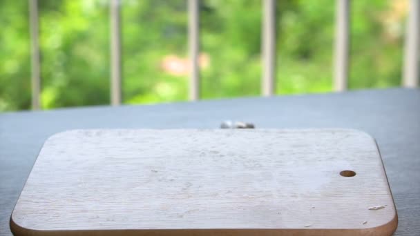 Glasierter Donut fällt auf Holztablett auf Tisch — Stockvideo