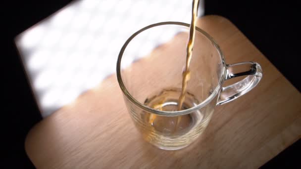 Verter té en la taza de vidrio y luego tomar la taza de la mano — Vídeos de Stock