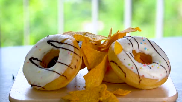 Chips cayendo sobre Donuts Insalubres — Vídeo de stock