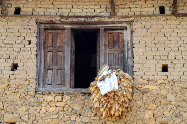 Maize hanging from the window of a traditional Nepal house