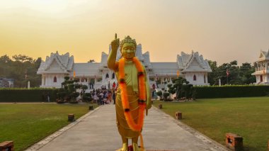 : Lumbini, Nepal - 10 Kasım 2018: İnsanlar ve Royal Thai Manastırı Lumbini hayran turistler. Gautam Buddha Statue ön planda.
