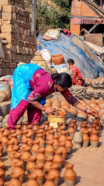 Bhaktapur, Nepal - 8 Aralık 2018: kil tencere seramik Meydanı'nda boyama orta yaşlı bir kadın.