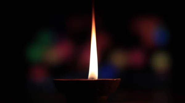 Uma Vela Uma Lâmpada Manteiga Com Fundo Colorido Bokeh — Fotografia de Stock