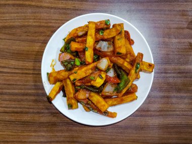 Baharatlı patates kızartması veya Cips soğuk beyaz bir tabaktabakta servis