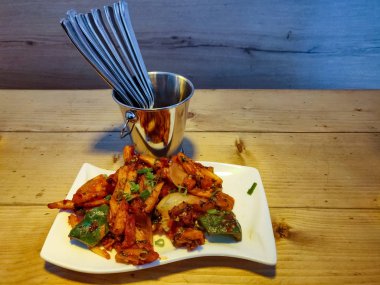 Baharatlı patates kızartması veya Cips soğuk beyaz bir tabaktabakta servis