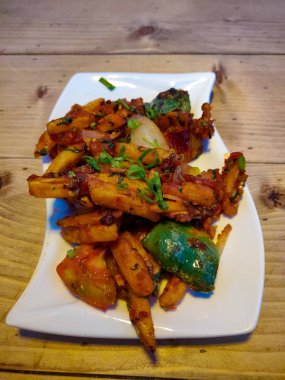 Baharatlı patates kızartması veya Cips soğuk beyaz bir tabaktabakta servis