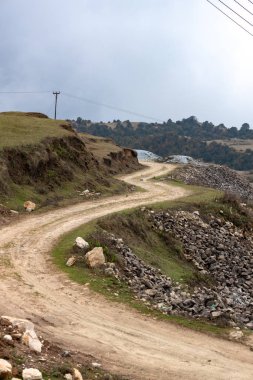 Uzak tepe bölgesinde virajlı dar toprak yol