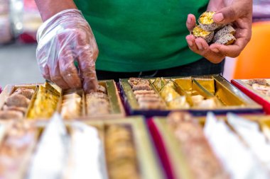 Diwali festivali için bir kutuda şeker düzenleyen bir adamın eli.