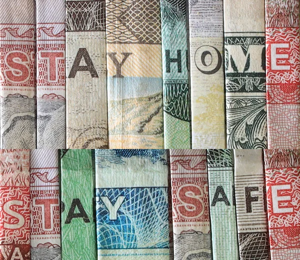 Stay Home Stay Safe safety message. Letters used from Nepali, Dollar and Riyal bank notes. Extreme closeup.