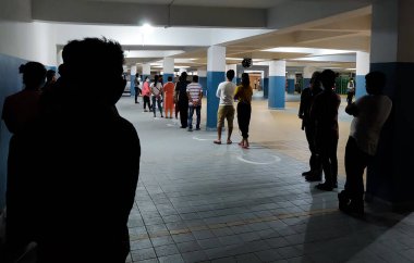 İnsanlar marketin önünde Sosyal Mesafe Uygulaması yapıyor. Müşteriler COVID-19 'un yayılmasını önlemek için iki metre mesafede dairenin içinde duruyorlar.