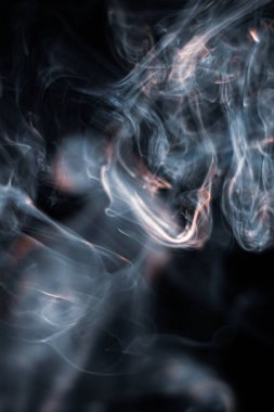 Tütsüden çıkan beyaz duman koyu arkaplanda izole edilmiş.