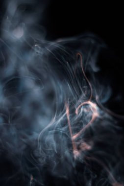 Tütsüden çıkan beyaz duman koyu arkaplanda izole edilmiş.