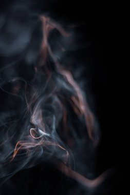 Tütsüden çıkan beyaz duman koyu arkaplanda izole edilmiş.