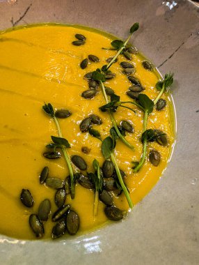 Dikey balkabağı kremalı çorba mikro yeşiller ve tohumlarla