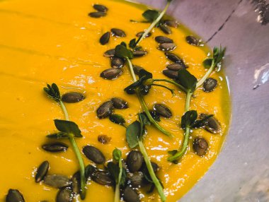 Çekirdekli ve mikro yeşillikli balkabağı kremalı çorba.