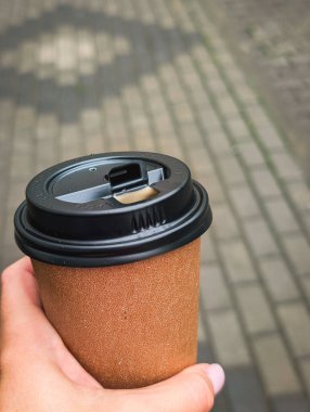 Şehir caddesinde elinde dikey kahve fincanı