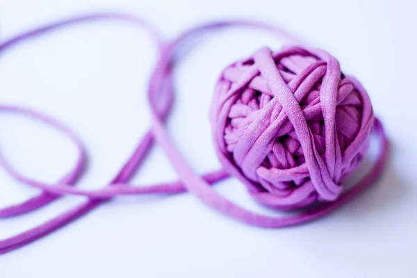 Tangle from a pink knitted thread on a light background