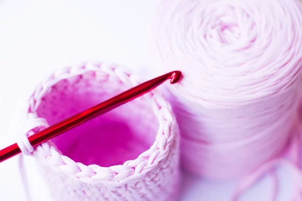 Knitted basket with a red crochet from knitted yarn of lilac color