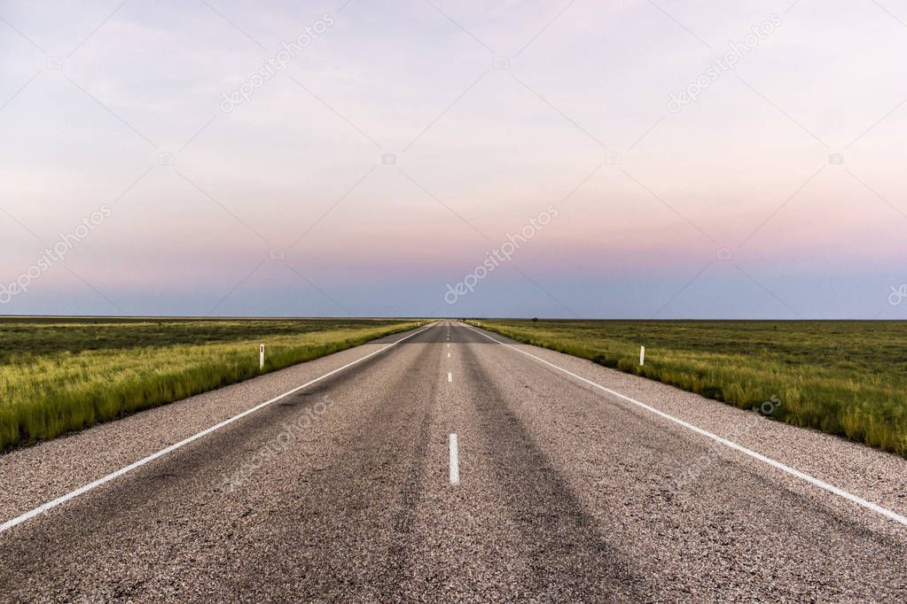 straight road through the outback of Australia, after a beautiful sunset