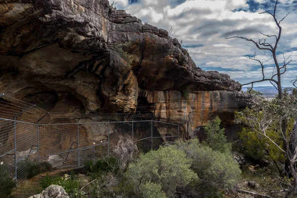 Blick über eine Höhle der Ureinwohner, hinter einem Zaun in Australien — Stockfoto