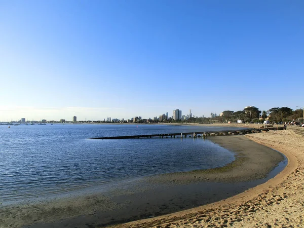 Melbourns CBD in the discance from St. Kilda Beach, Melbroune, Australia on a cloudless sunset Royalty Free Stock Photos