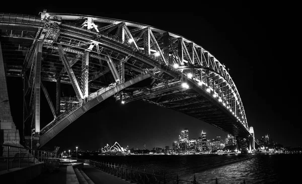 Lado este del puente del puerto de Sydney en nihgt con reflejo brillante en las aguas borrosas del puerto — Foto de Stock
