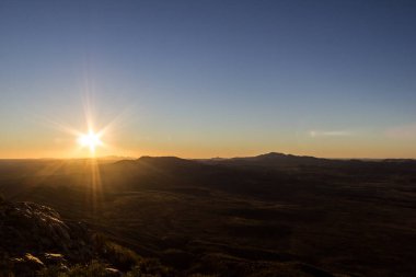 Alice Springs'in hemen dışındaki Sonder Dağı'nın tepesinden gün batımı manzarası, West Macdonnel National Park, Avustralya