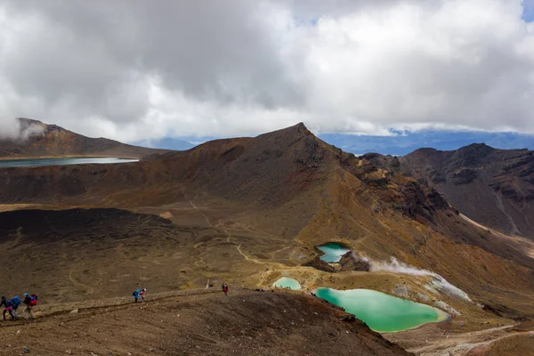 Veduta paesaggistica dei colorati laghi di Smeraldo e paesaggio vulcanico con escursionisti a piedi, Parco nazionale del Tongariro, Nuova Zelanda — Foto Stock