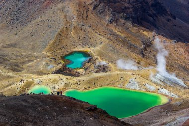 Renkli Zümrüt göllerinin ve volkanik manzaranın manzarası. Yürüyüşçülerin yürüdüğü yer. Tongariro Ulusal Parkı, Yeni Zelanda.