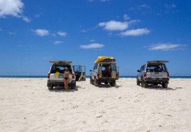Cars parking on the main transportation highway on Fraser Island - wide wet sand beach coast facing Pacific ocean - long 75 miles beach clipart