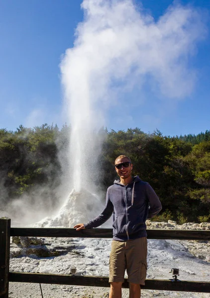 Νεαρός άνδρας στέκεται μπροστά από την έκρηξη της Lady Knox Geyser, Wai-O-Tapu Thermal Wonderland, Rotorua, Νέα Ζηλανδία — Φωτογραφία Αρχείου