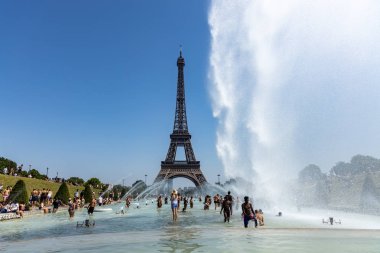 Paris, Fransa, 27 Haziran 2019: Turistler ve yerliler güçlü tazyikli su altında Trocadero'nun Jardins du Trocad ro Guardians'ında banyo yapıyor. 45 derece celius üzerinde yeni ısı kayıtları